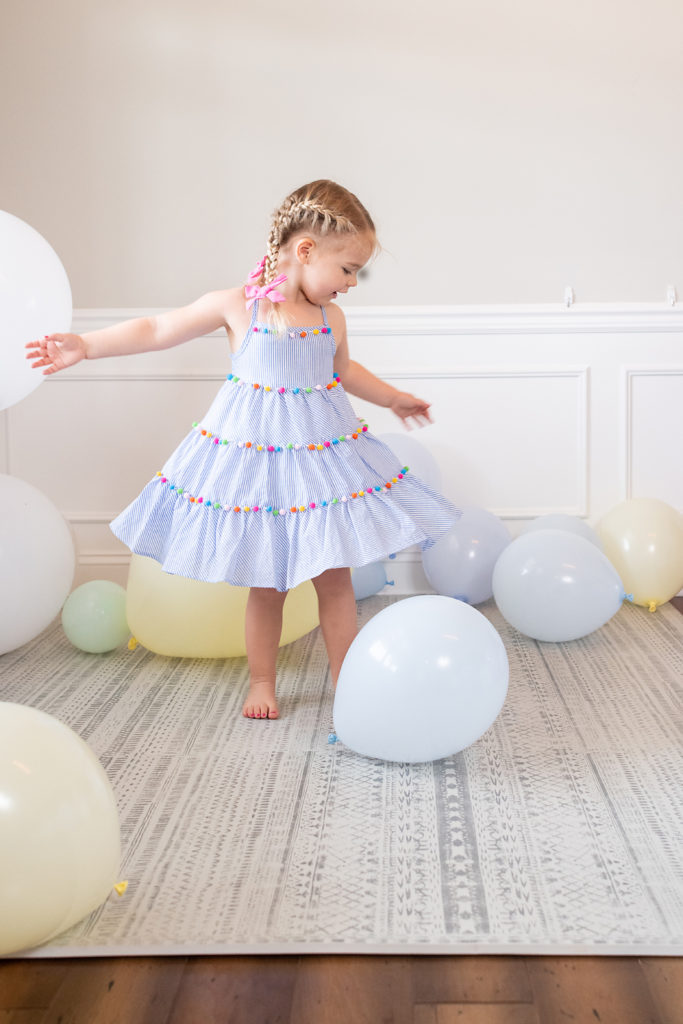 Three Year old girl twirls in balloons
