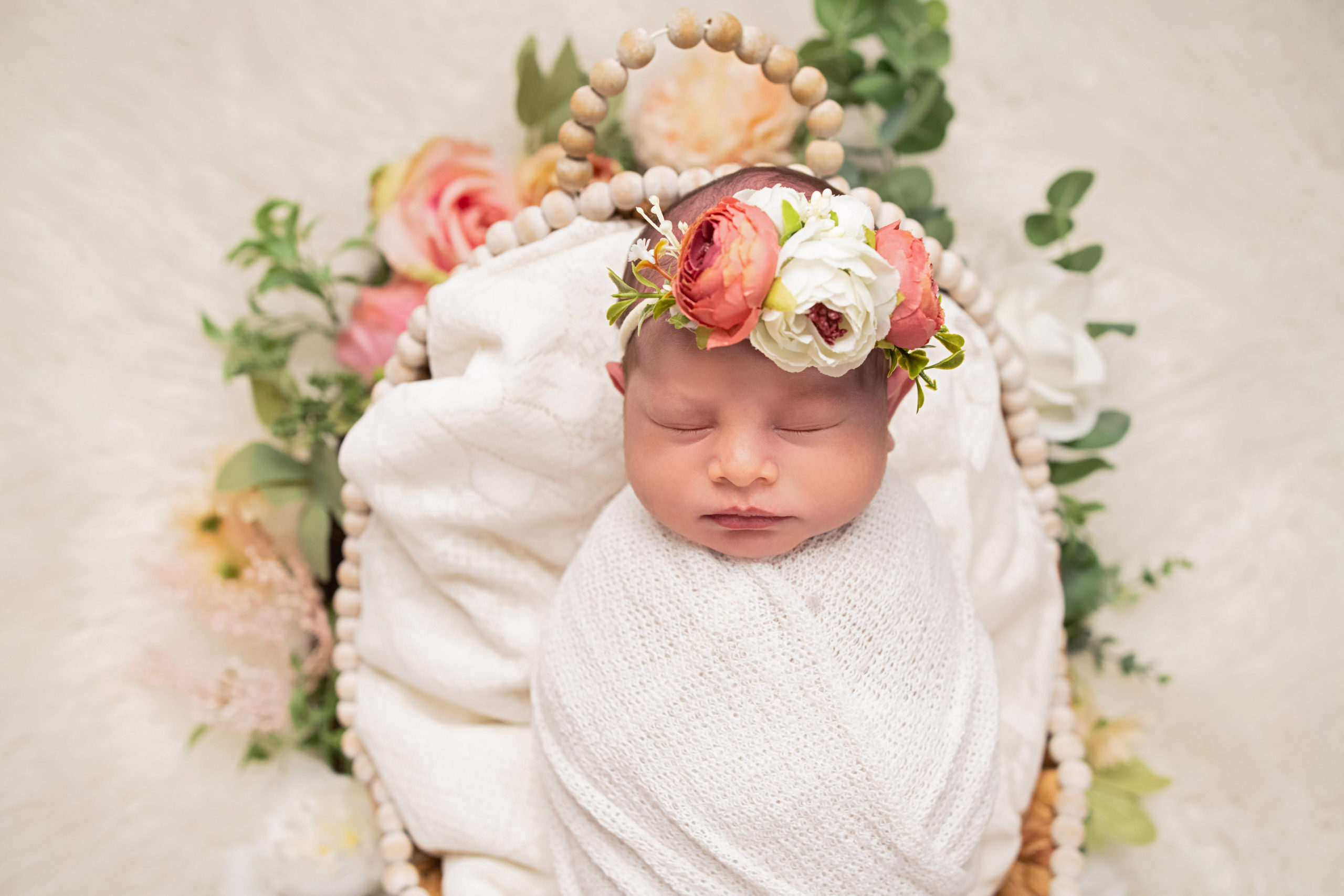 Newborn Baby in basket with flowers