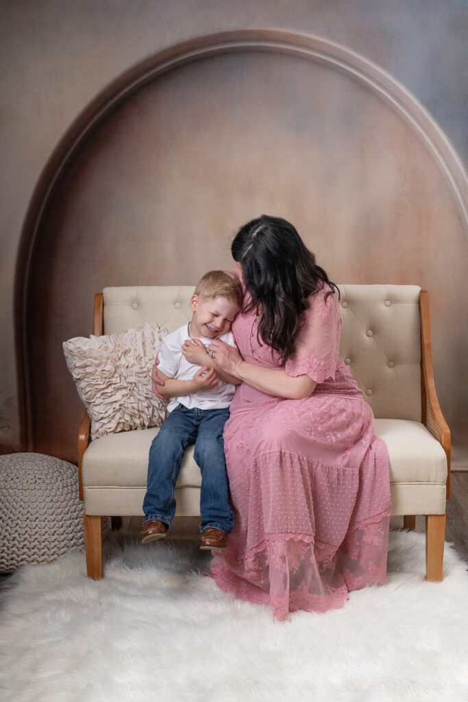 Mom lovingly tickling her son Mother's Day Portraits